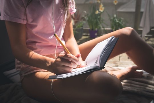 Woman writing in diary at home